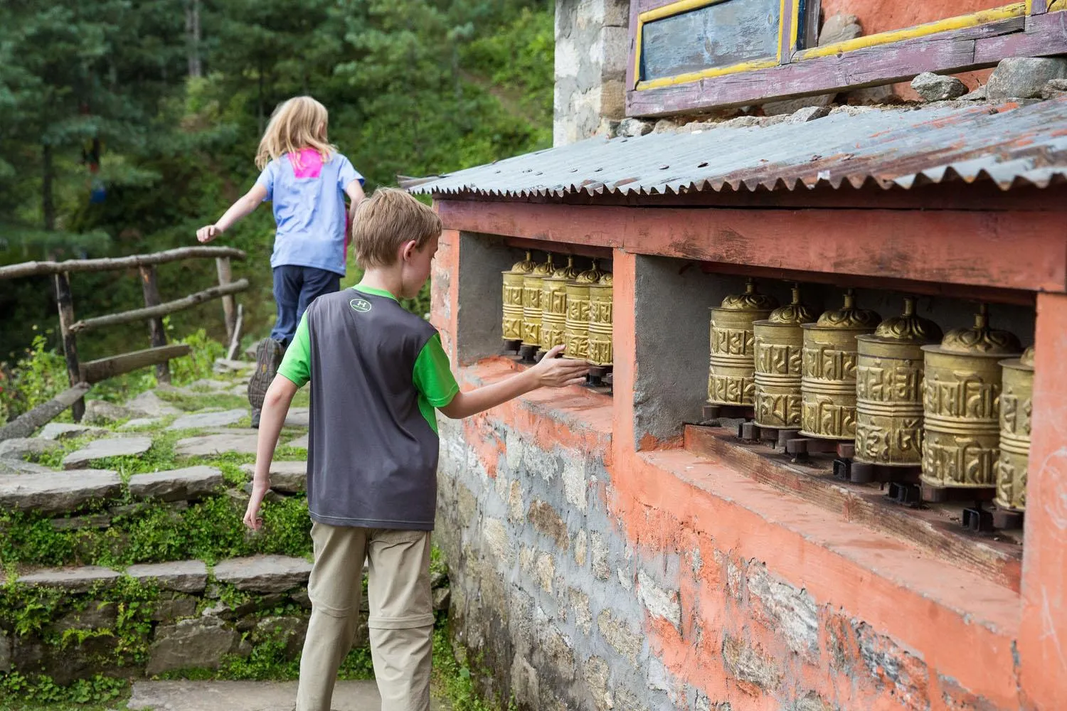 Kids spinning prayer wheels on a Nepal trekking route.